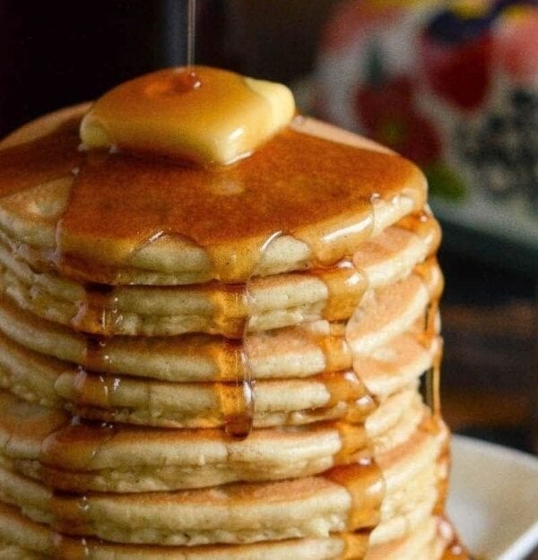 Close up of the syrup drizzling down low carb keto pancakes. 
