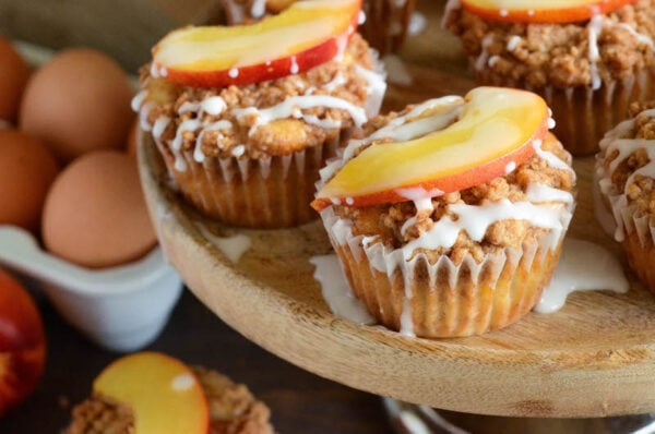 Peaches & Cream Streusel Muffins: tender muffins loaded with fresh peaches and cinnamon are topped with a sweet streusel topping and creamy vanilla icing.