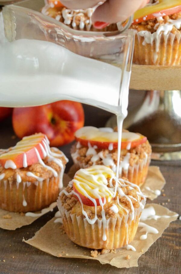 Peaches & Cream Streusel Muffins: tender muffins loaded with fresh peaches and cinnamon are topped with a sweet streusel topping and creamy vanilla icing.