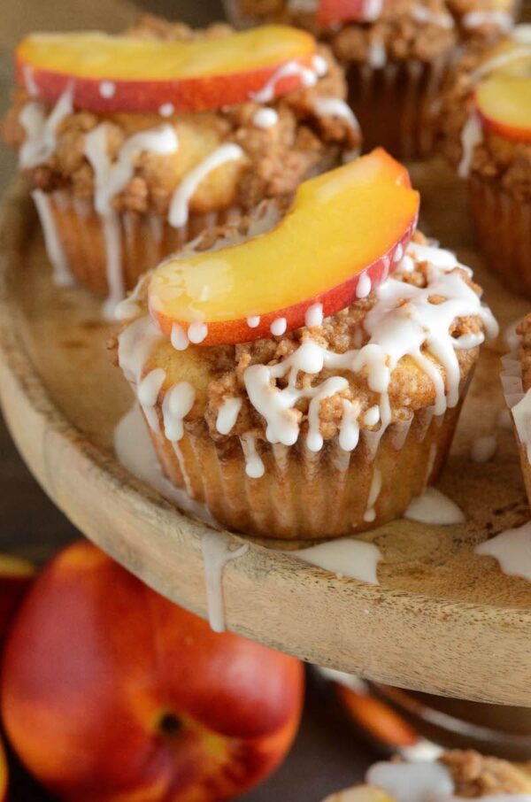 Peaches & Cream Streusel Muffins: tender muffins loaded with fresh peaches and cinnamon are topped with a sweet streusel topping and creamy vanilla icing.