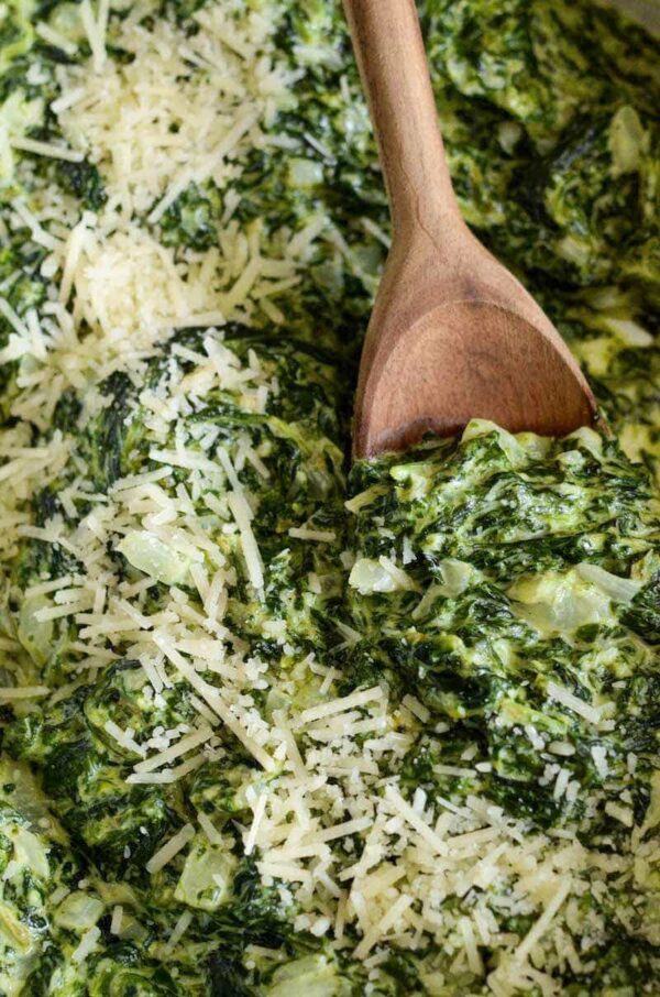 Up close photo of creamed spinach with parmesan sprinkled on top. 