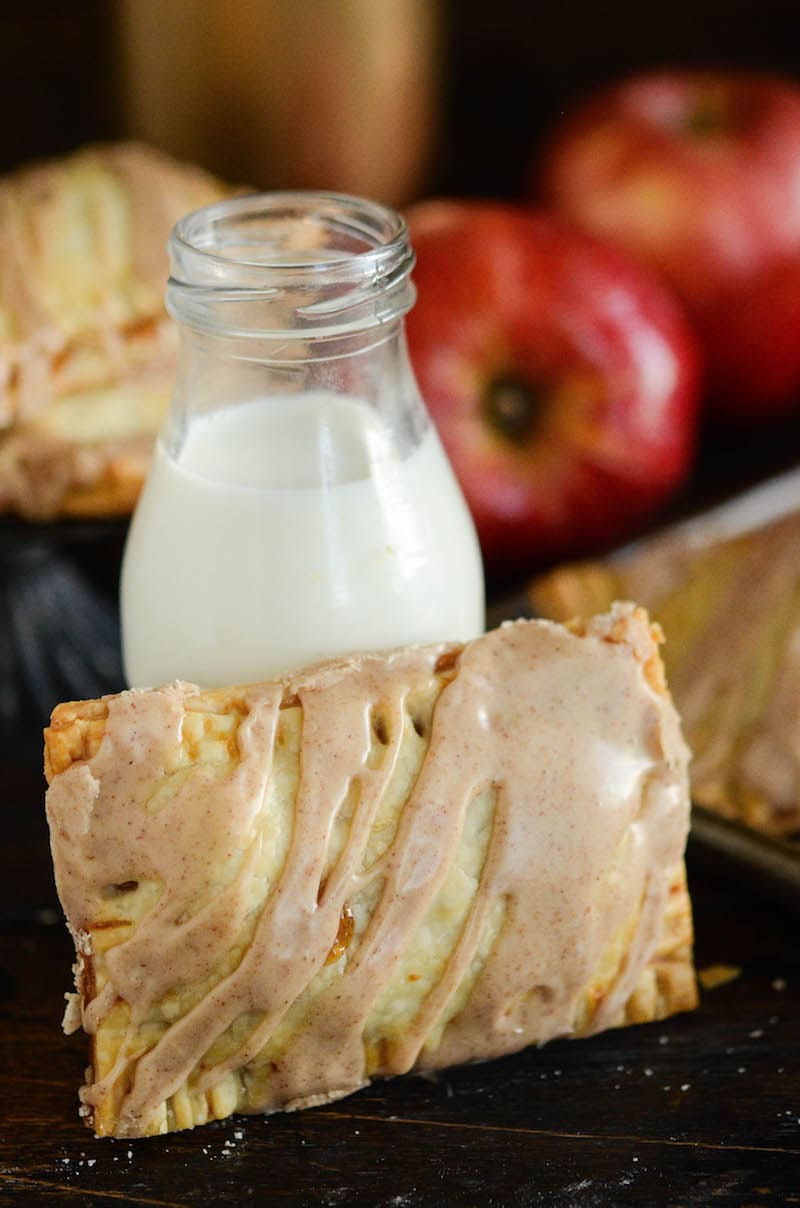 Whole apple pie Poptart with a glass of milk. 