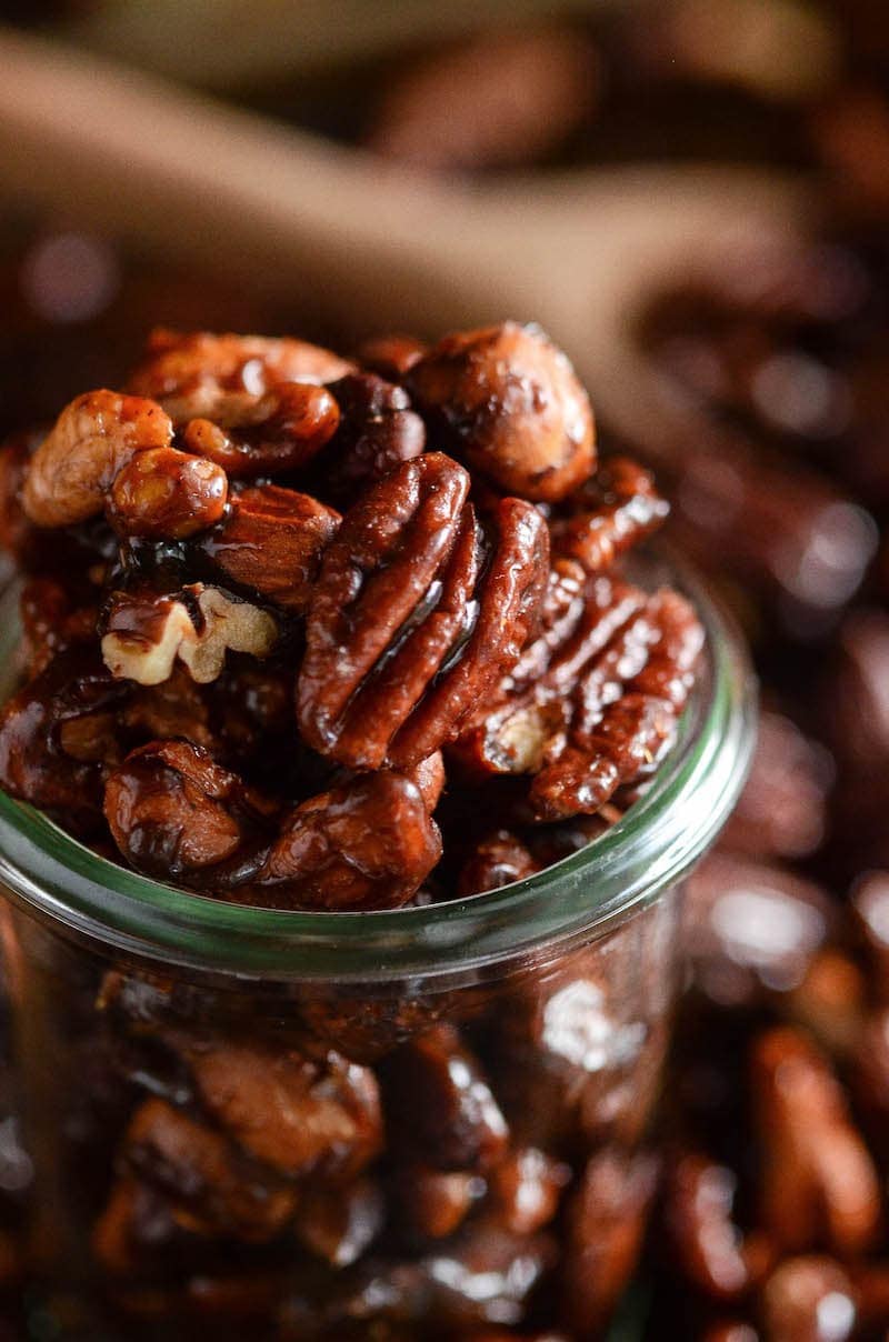 A close up of pumpkin spice candied nuts in a glass jar.