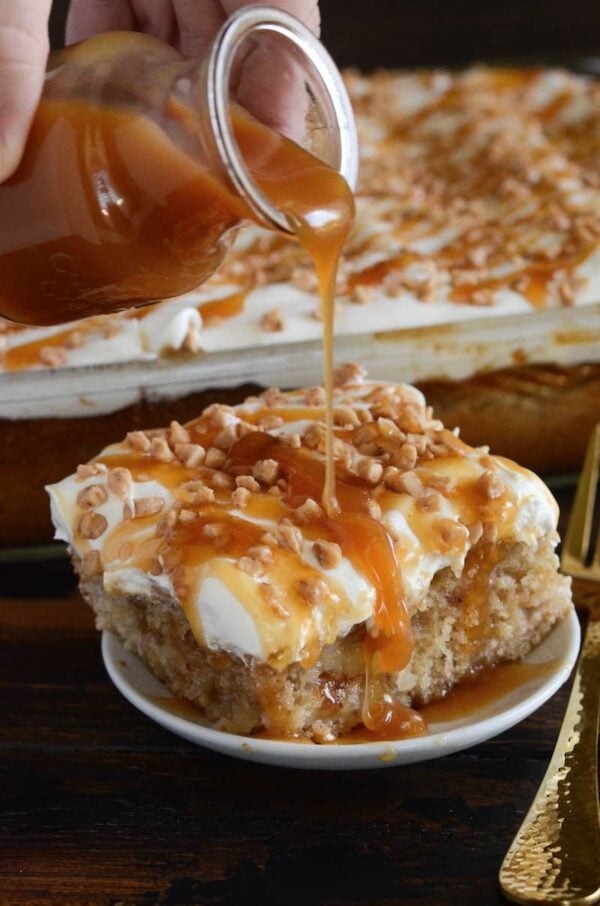 Caramel Apple Toffee Cake: a homemade - from scratch - poke cake is filled with bites of apple, toffee, caramel sauce and topped with sweet whipped cream!