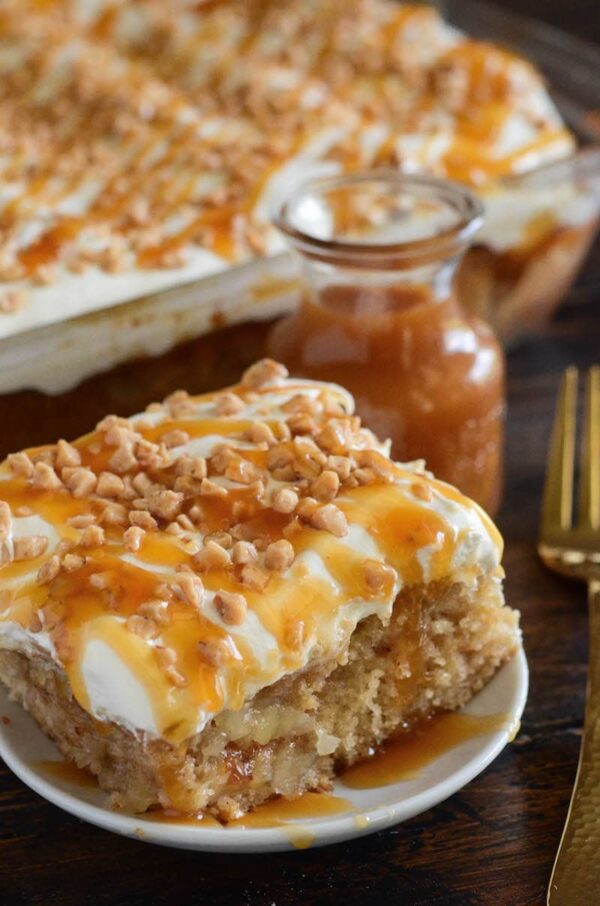 Caramel Apple Toffee Cake: a homemade - from scratch - poke cake is filled with bites of apple, toffee, caramel sauce and topped with sweet whipped cream!