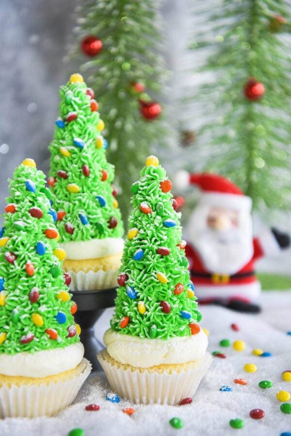 Christmas Tree Cupcakes: these festive Christmas decorated cupcakes are made with buttercream frosting, mini m&ms and hidden ice cream cones for the base!