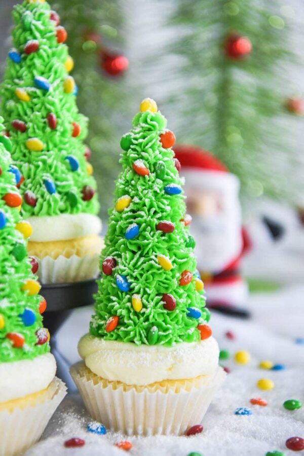 Christmas Tree Cupcakes: these festive Christmas decorated cupcakes are made with buttercream frosting, mini m&ms and hidden ice cream cones for the base!