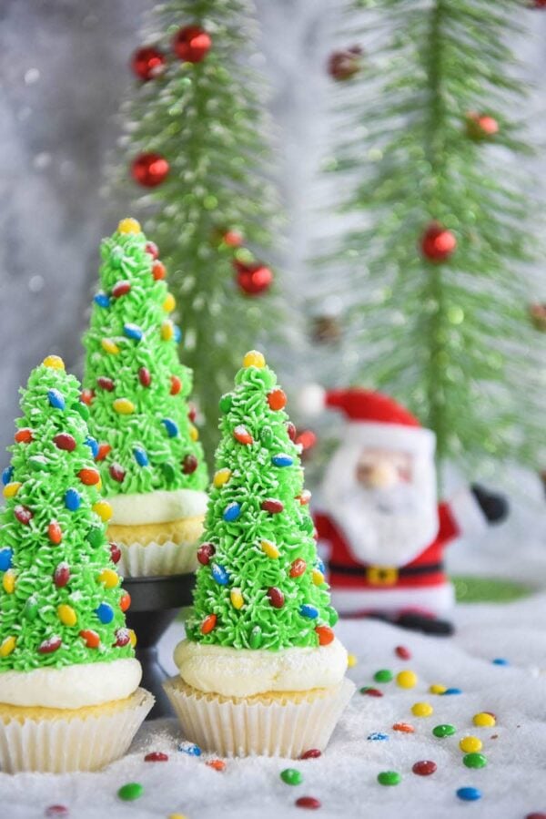 Christmas Tree Cupcakes: these festive Christmas decorated cupcakes are made with buttercream frosting, mini m&ms and hidden ice cream cones for the base!