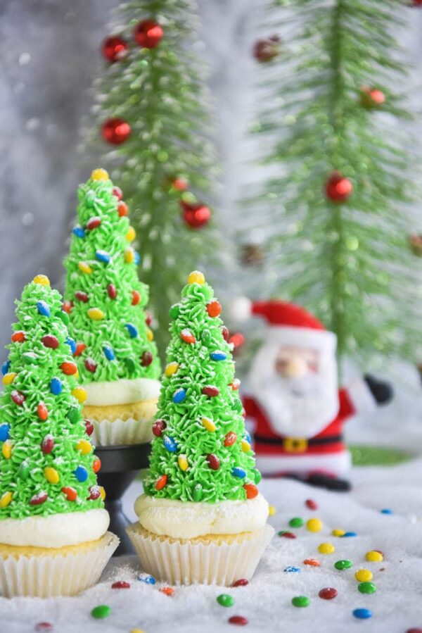 Christmas Tree Cupcakes: these festive Christmas decorated cupcakes are made with buttercream frosting, mini m&ms and hidden ice cream cones for the base!