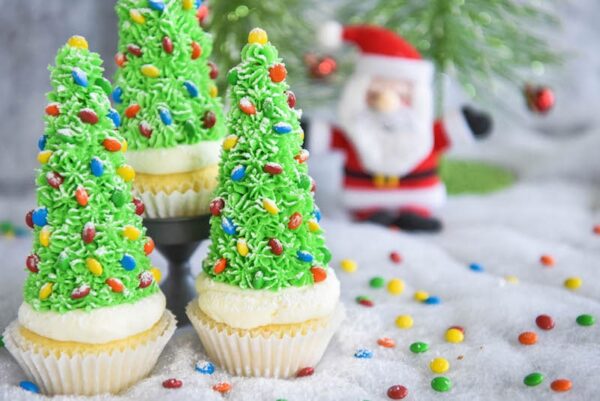 Christmas Tree Cupcakes: these festive Christmas decorated cupcakes are made with buttercream frosting, mini m&ms and hidden ice cream cones for the base!