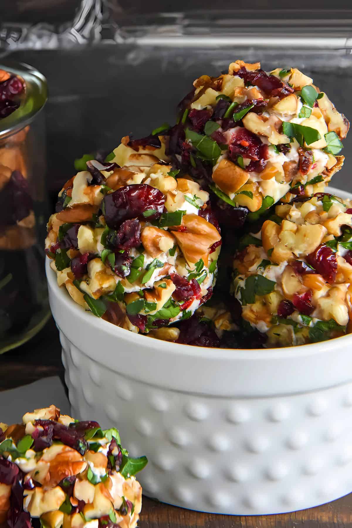 A white bowl is filled with Christmas cheese balls.