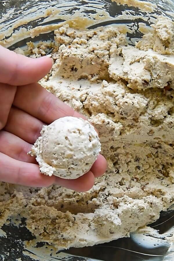 A scoop of the goat cheese mixture is being picked up from a bowl.