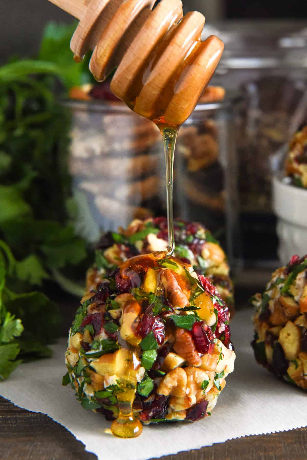 A generous drizzle of sweet honey on a single Christmas goat cheese ball.