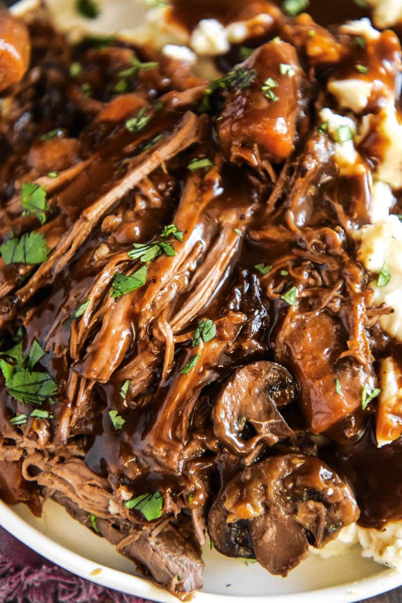 Slow Cooker Pot Roast shredded on a plate.