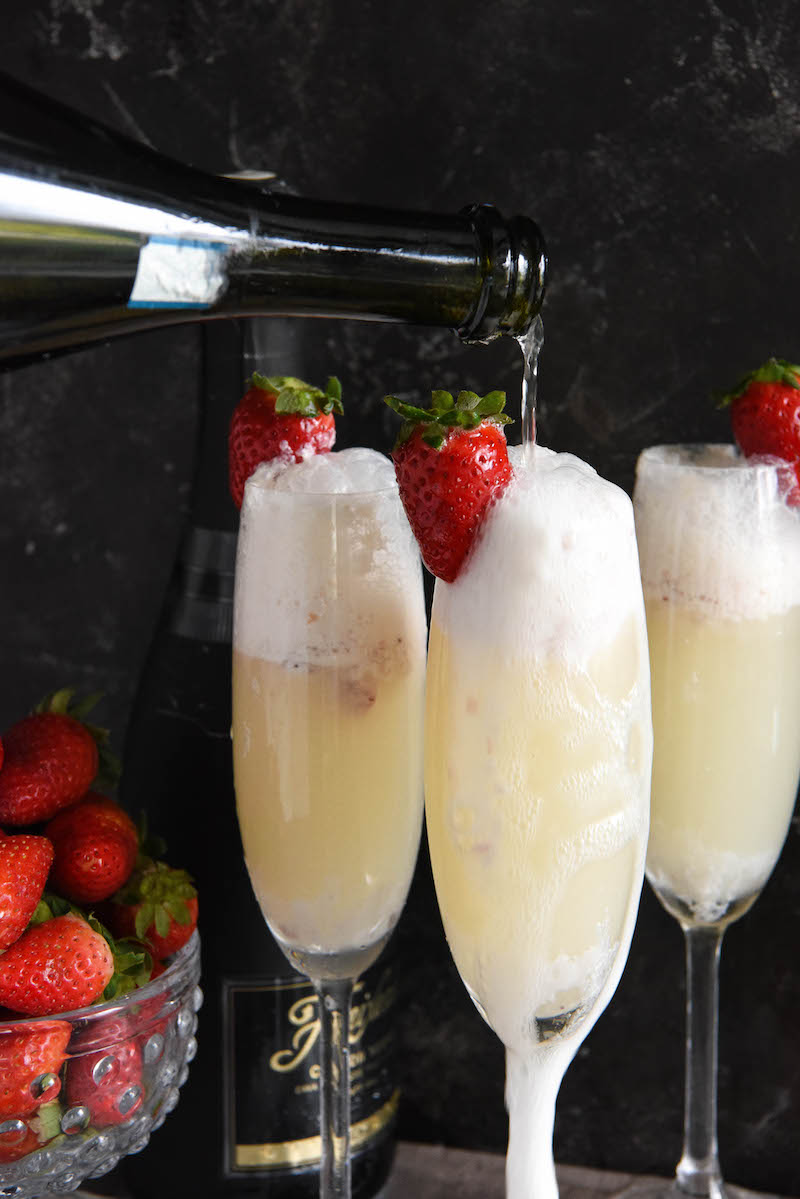 Three strawberry champagne floats garnished with fresh strawberries.