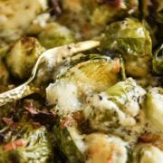 Baked brussel sprout casserole with a fork picking up a sprout out of the dish.