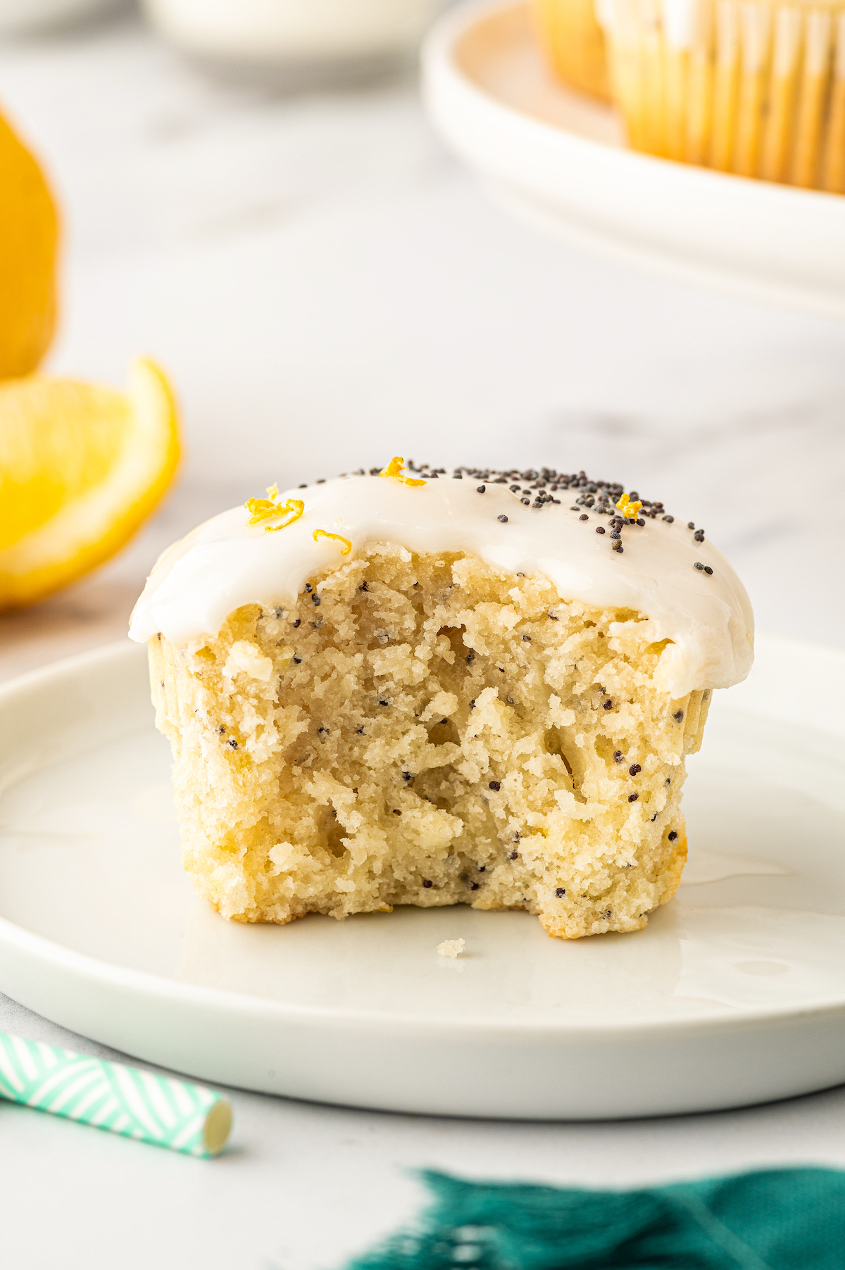 A lemon poppy seed muffin with a bite taken out of it.
