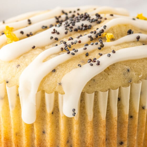 A lemon poppy seed muffin with a drizzle of glaze.