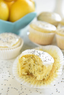 A Glazed Lemon Poppyseed Muffin in its Opened Wrapper with Once Bite Taken Out of the Muffin