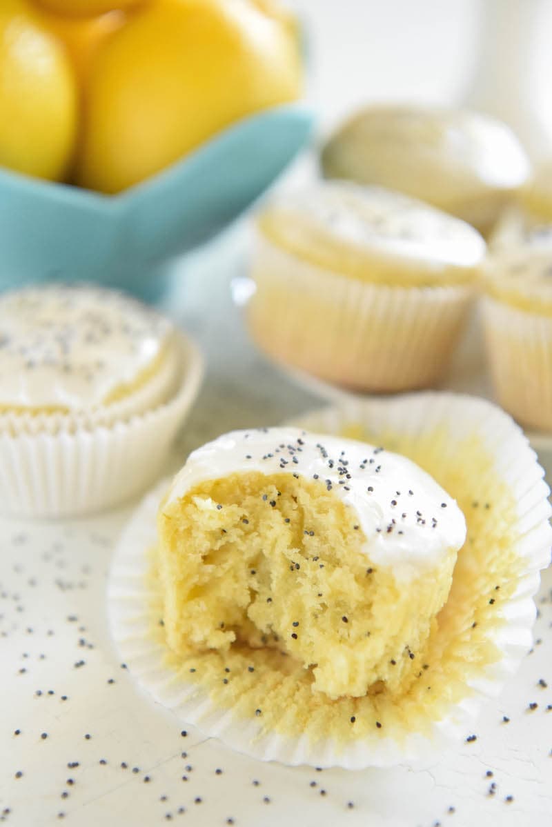A Glazed Lemon Poppyseed Muffin in its Opened Wrapper with Once Bite Taken Out of the Muffin