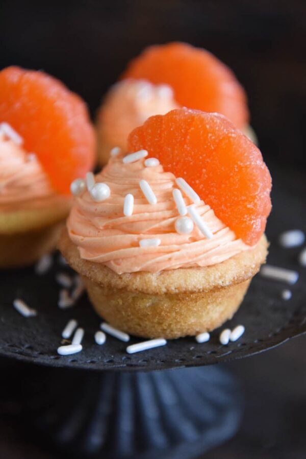 Orange Creamsicle Cookie Cups: soft sugar cookie cups are filled with orange creamsicle icing and topped with orange candy wedges. #orange #cookie