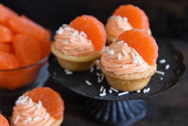 Orange Creamsicle Cookie Cups: soft sugar cookie cups are filled with orange creamsicle icing and topped with orange candy wedges. #orange #cookie