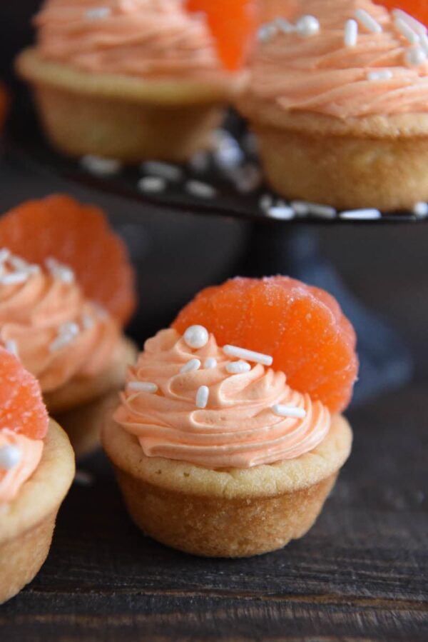 Orange Creamsicle Cookie Cups: soft sugar cookie cups are filled with orange creamsicle icing and topped with orange candy wedges. #orange #cookie