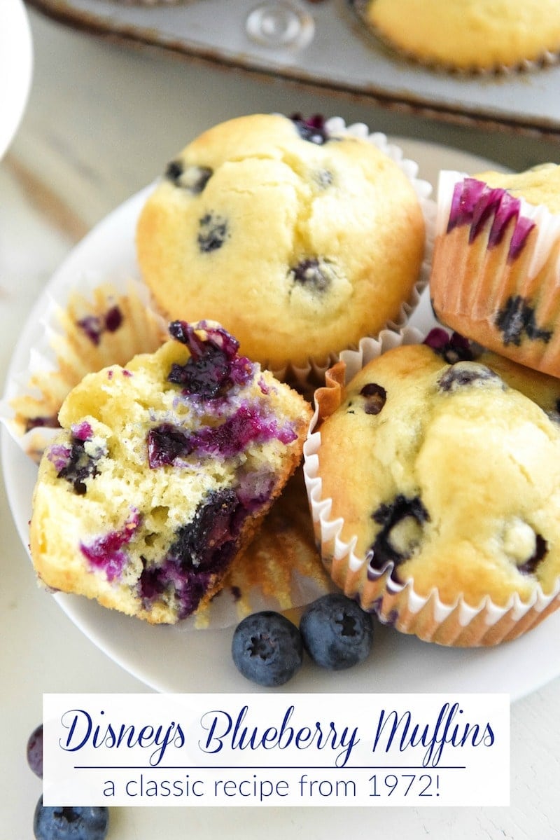 A Dessert Plate Holding Four Blueberry Muffins with One Split in Half to Show the Fluffy Interior