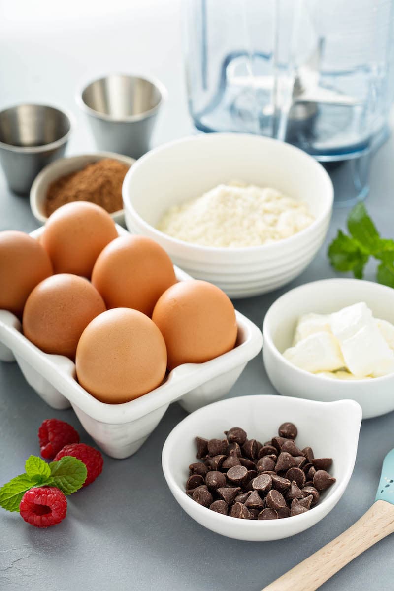 Eggs, Almond Flour, Cream Cheese and the Rest of the Chocolate Chip Pancake Ingredients on a Gray Countertop