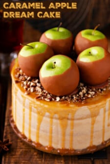 Homemade caramel apple cake with a salted caramel drizzle, caramel apples, and chopped pecans on top.