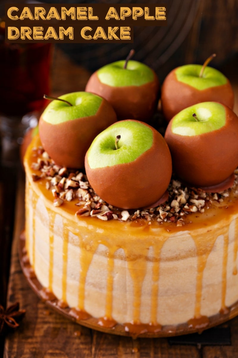 Homemade caramel apple cake with a salted caramel drizzle, caramel apples, and chopped pecans on top. 