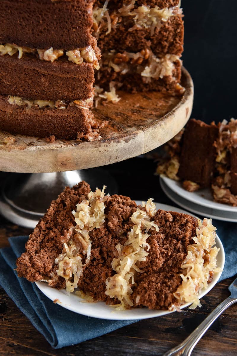 A Piece of Chocolate Cake with Coconut Frosting on a Dessert Plate Next to a Fork