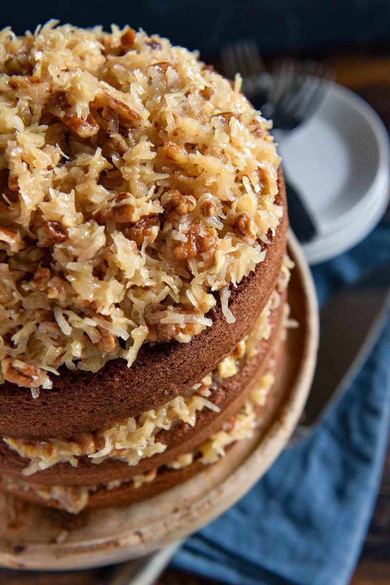 A German Chocolate Layer Cake on Top of a Light Brown Cake Stand