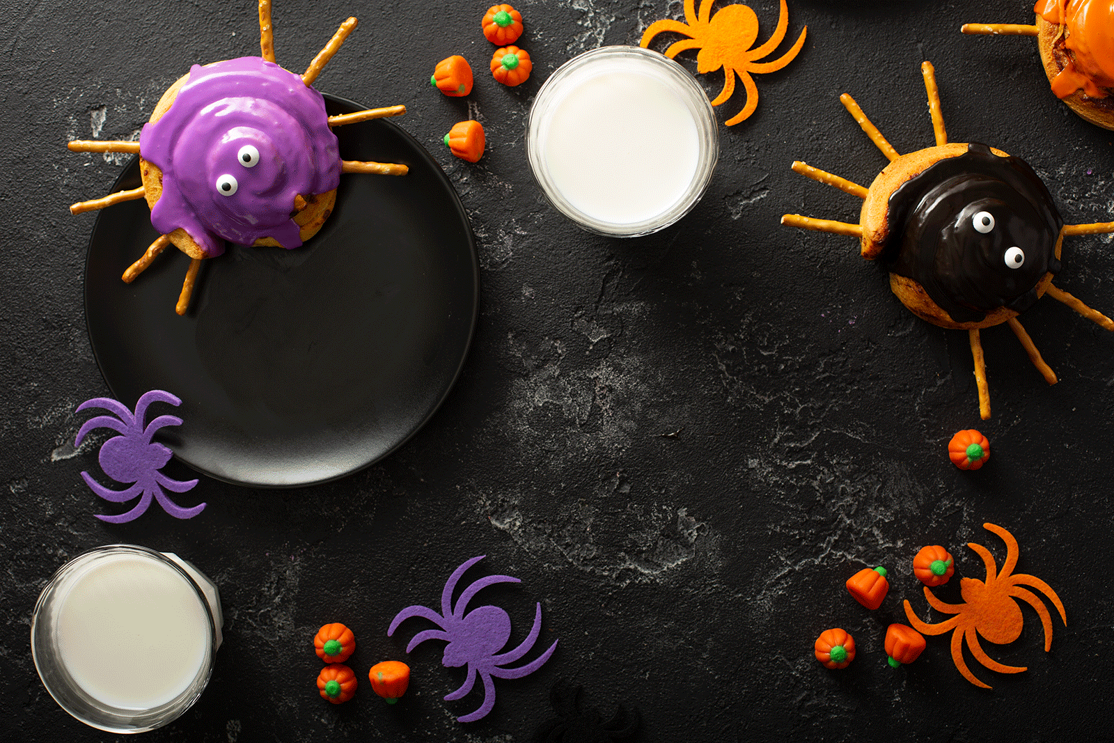 A Halloween Breakfast Table with Spider Cinnamon Rolls and Candy Pumpkins