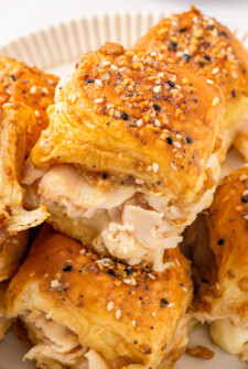 A platter of warm turkey sliders with buttery Dijon topping and everything bagel seasoning.