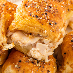 A platter of warm turkey sliders with buttery Dijon topping and everything bagel seasoning.