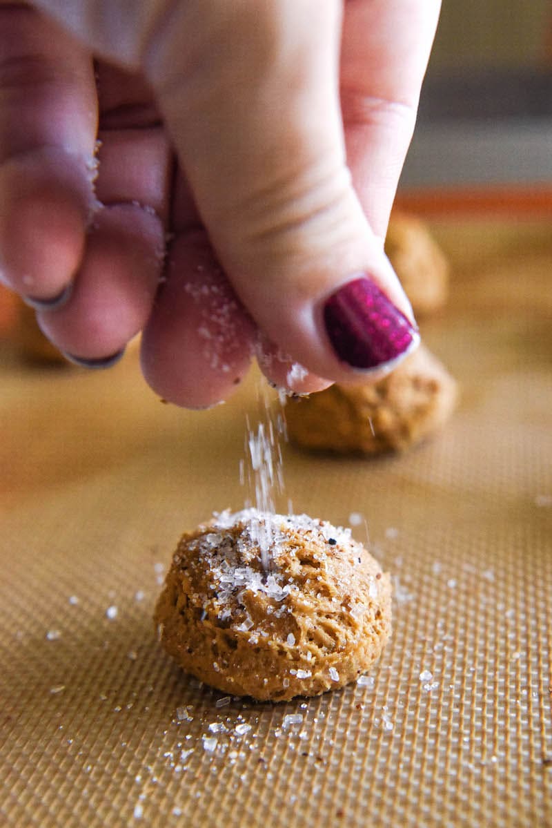 Apple cider cookie dough being sprinkled with instant apple cider and coarse sugar.