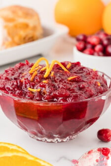 Bowl of cranberry orange sauce recipe with an orange twist on top.