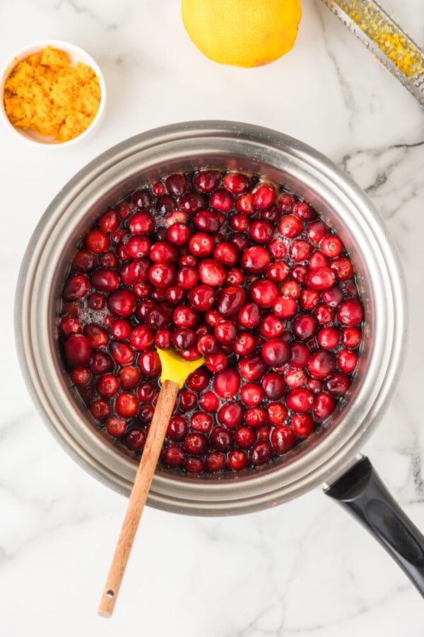 Adding the fresh whole cranberries to sauce pot.