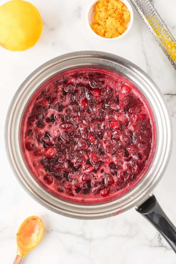 Cooking the cranberry sauce until the cranberries begin to pop.