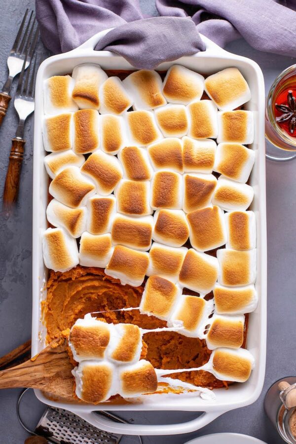 Sweet potato casserole topped with marshmallows in a white baking dish