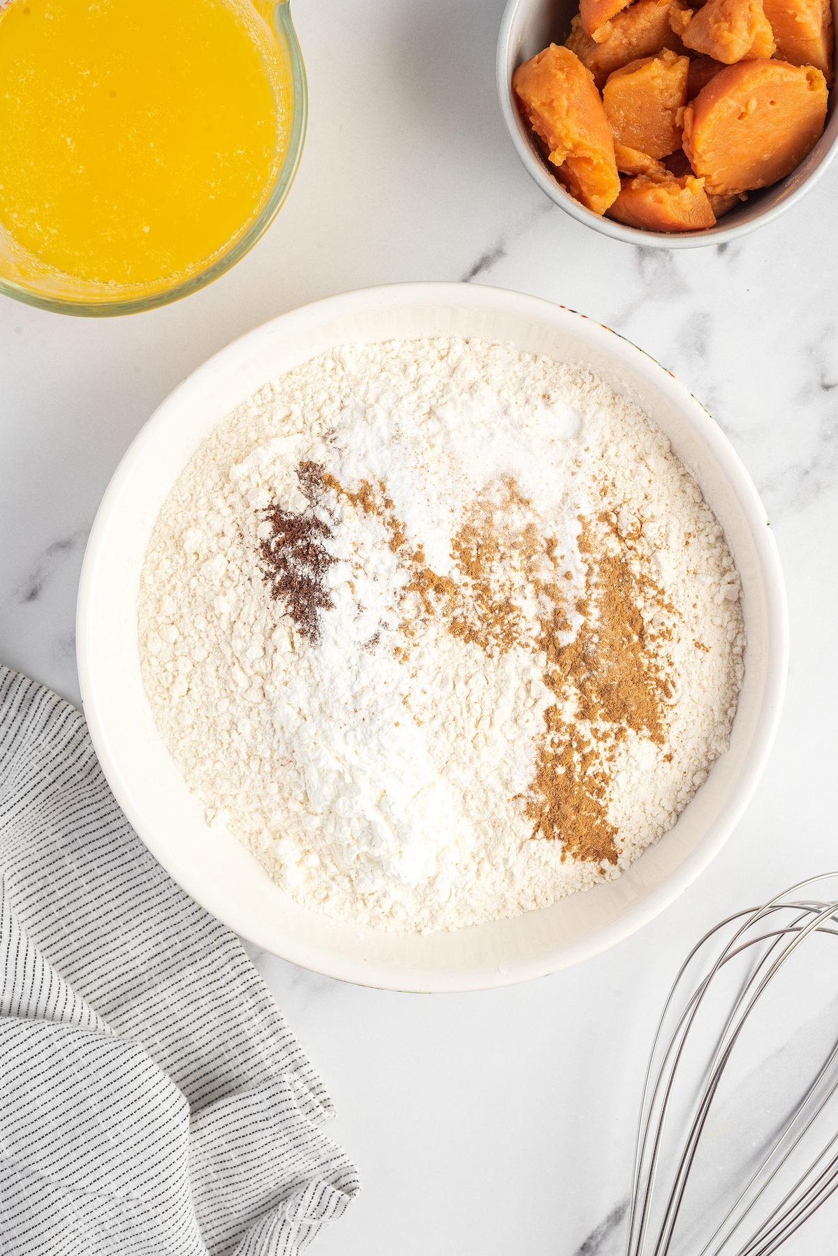 Flour, cinnamon, baking powder, and other ingredients in a mixing bowl.