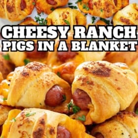 Pigs in a blanket appetizer on a baking sheet next to a serving plate.