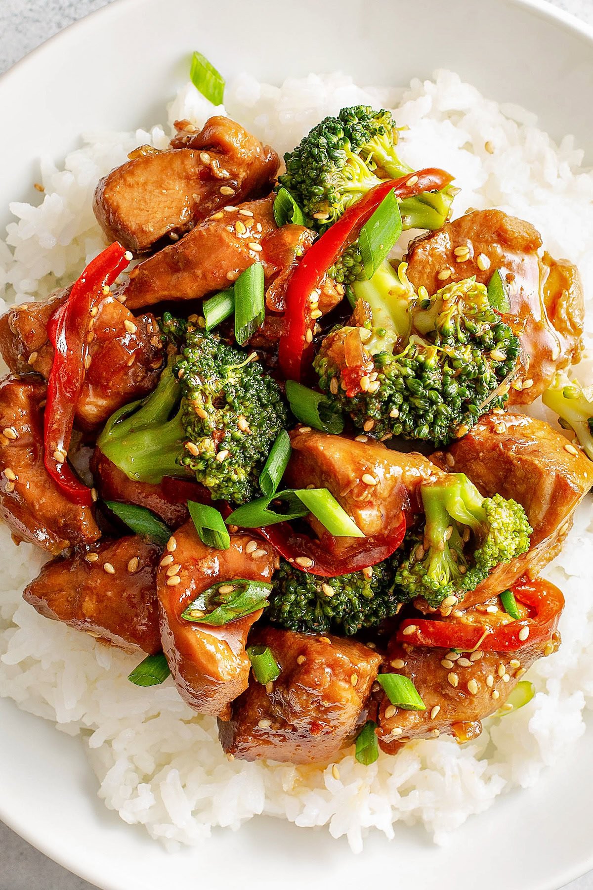 Thick, glossy sauce coats broccoli, red peppers and chicken breast bites. 