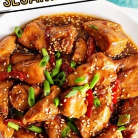 Green onions and sesame seeds are sprinkled on top of saucy sesame chicken.