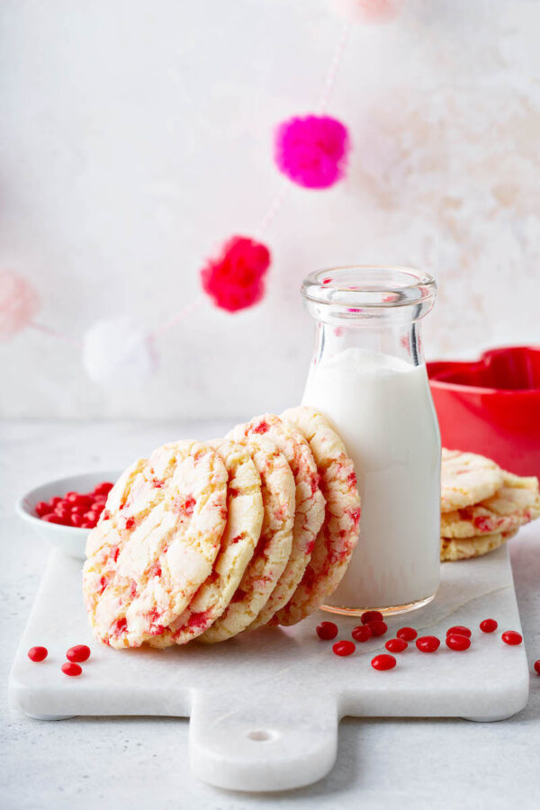 Red Hot Cookies: these Valentine’s Day Cookies start with a soft chewy sugar cookie that is loaded with crushed Red Hot Candies to create a speckled appearance. #RedHotCookies #SugarCookies #ValetinesDayCookies #ValentinesDayDessert #ValentinesDay #RedHots