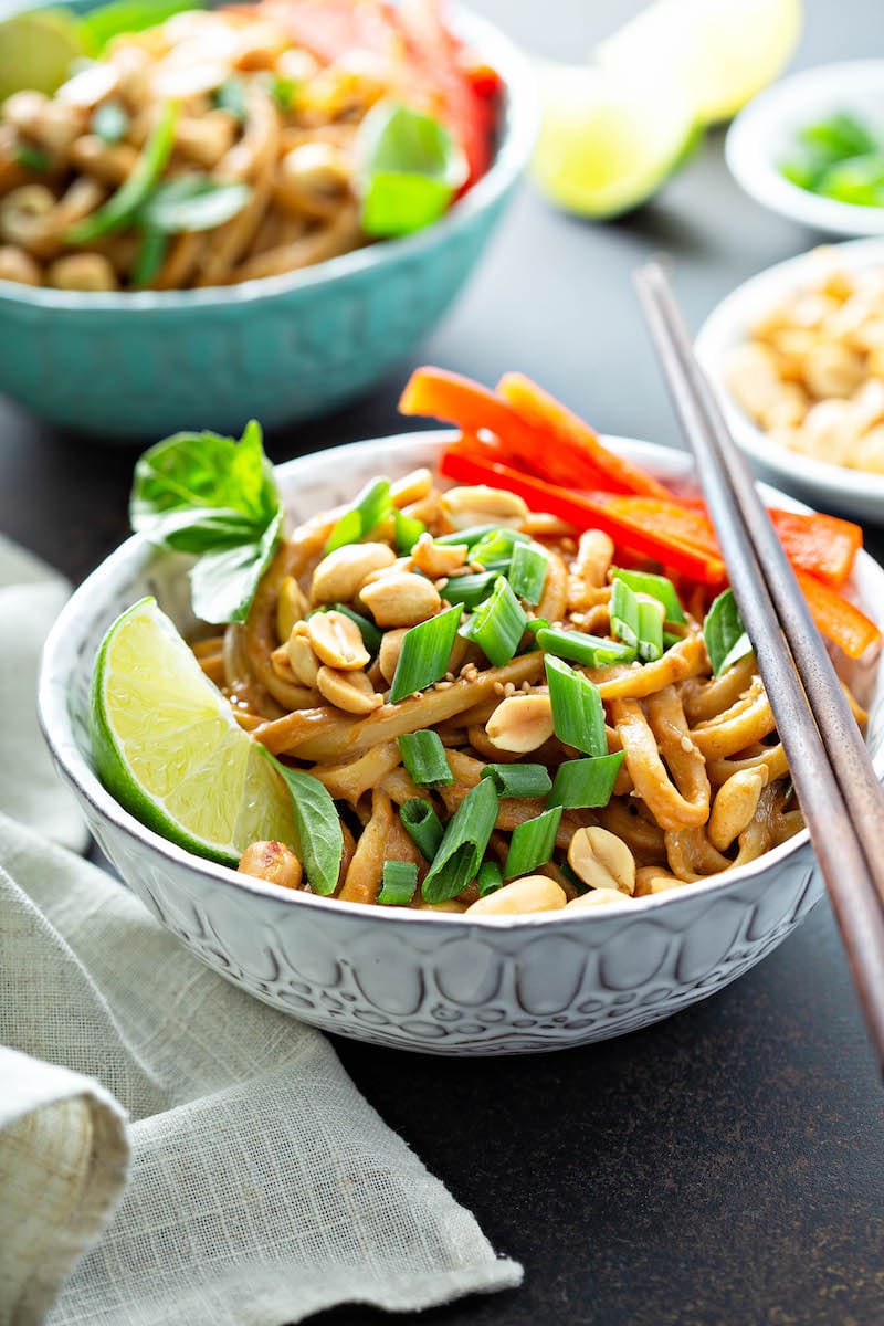 Thai peanut noodles in a bowl with chopsticks.