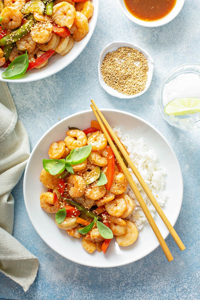 Teriyaki Shrimp StirFry served over white rice with chopsticks.