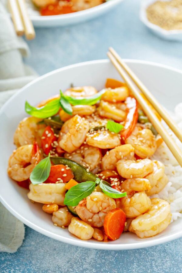 Teriyaki Shrimp StirFry i en skål serveres over ris med sesamfrø drysset på toppen. 