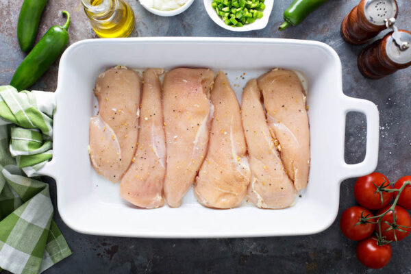 Chicken breasts in casserole dish with salt and pepper. 